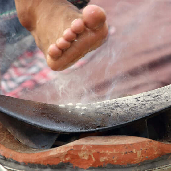 Foot over clay fire-pot receiving heat therapy in Preparation for Thai massage in Northern style.