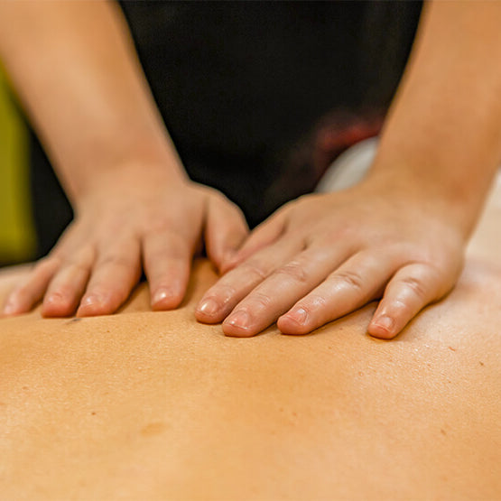 Massage therapist applying effleurage to patient's back