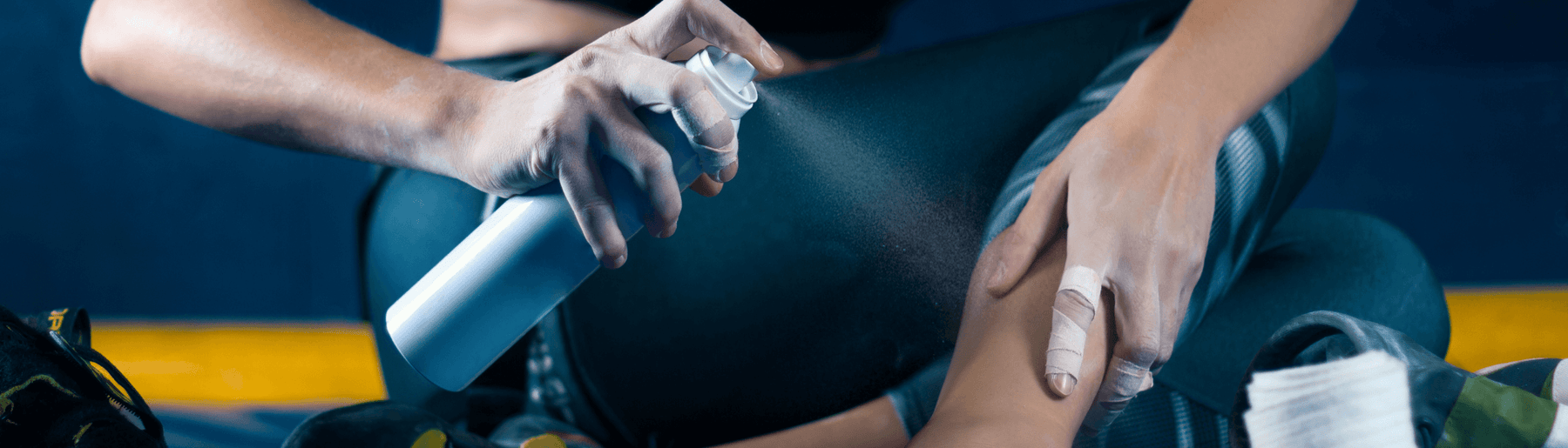 Female athlete spraying topical analgesic on sports injury