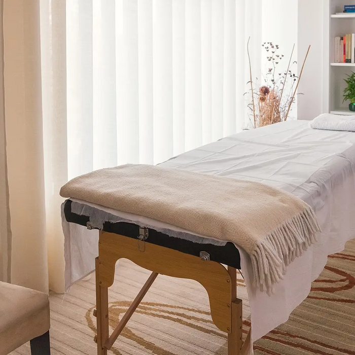 Professional massage treatment room with portable massage table illustrating common treatment table widths used by Canadian therapists