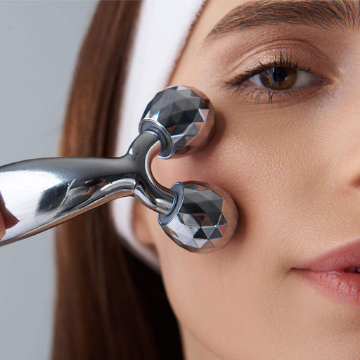 3D face and body massage roller on cheek bone of female model