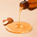 BodyBest Almond Sweet oil is being poured from amber glass jar