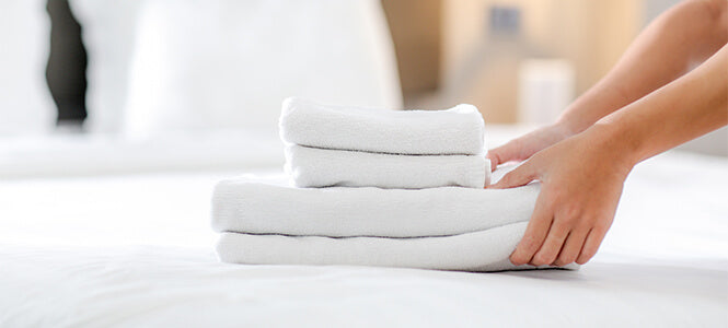 Towels stacked up on a bed