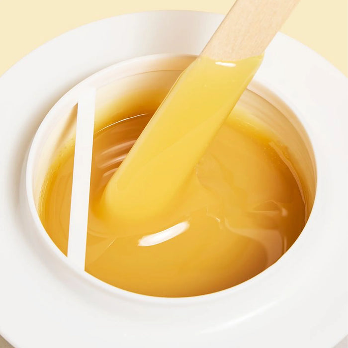 Epillyss Cocooning lukewarm depilatory gel wax is being used with wooden spatula