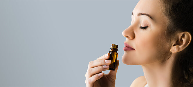 female smelling essential oil bottle
