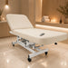 ilhouet-Tone sand-colored electric spa treatment table (Sahara Sand upholstery) shown in use in a professional spa setting