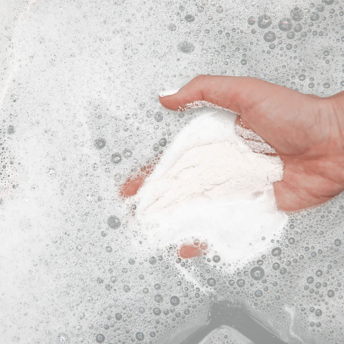 Adding Bathorium Ancient Oat Hydration Crush Bath Soak to warm bath water