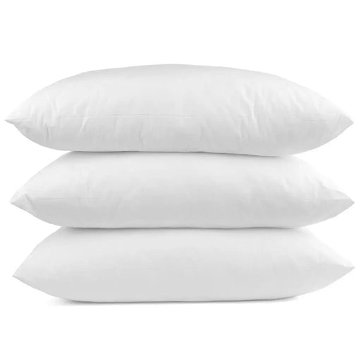Three white dacron filled pillows stacked on a white background
