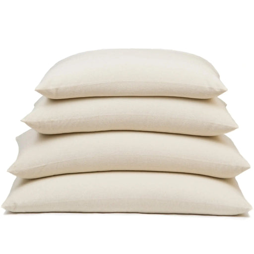 Stack of beige buckwheat stuffed pillows on a white background
