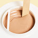 Epillyss chocolate lukewarm depilatory soft wax is in use with wooden spatula, wax consistency and wax color is being shown