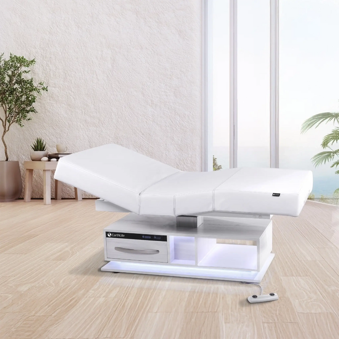 Earthlite Everest Eclipse 2.0 electric treatment table in a luxury spa treatment room with adjustable salon top, warming drawer, integrated storage, and LED-lit base