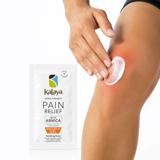 Hand applying white Kalaya Extra Strength Pain Relief Emulsion Gel with Arnica to a sore knee, with the pain relief sachet displayed beside the application area, illustrating topical use for temporary relief of minor aches and joint discomfort.