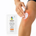 Hand applying white Kalaya Extra Strength Pain Relief Emulsion Gel with Arnica to a sore knee, with the pain relief sachet displayed beside the application area, illustrating topical use for temporary relief of minor aches and joint discomfort.