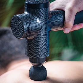 Massage gun being used on a models back