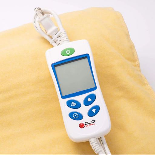 Digital remote control with blue and green buttons on a yellow blanket